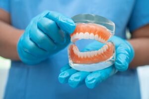 denture,,dentist,holding,dental,teeth,model,to,study,and,treat